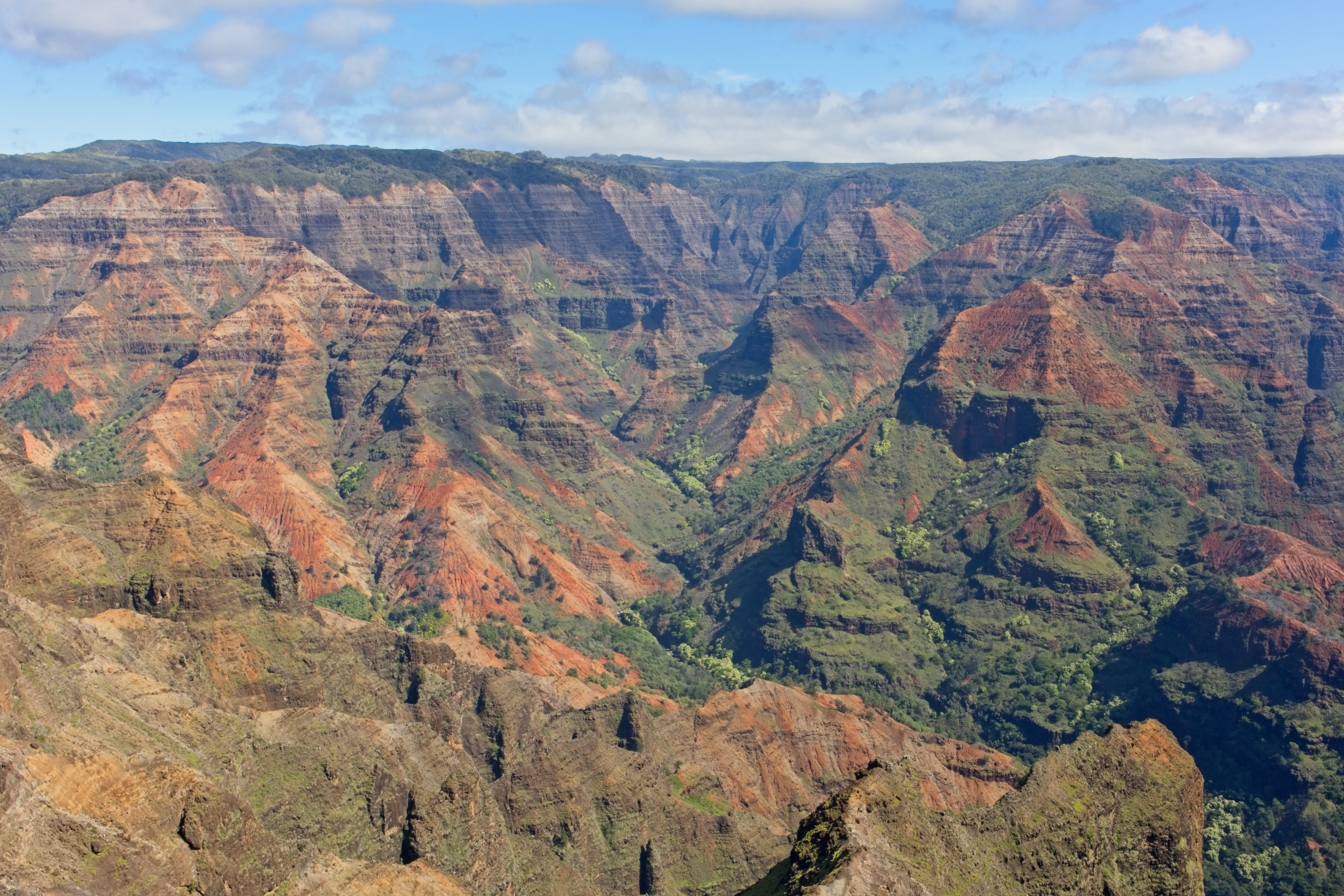 Layered red and brown ridges with green valleys at Waimea Canyon, Kauai.