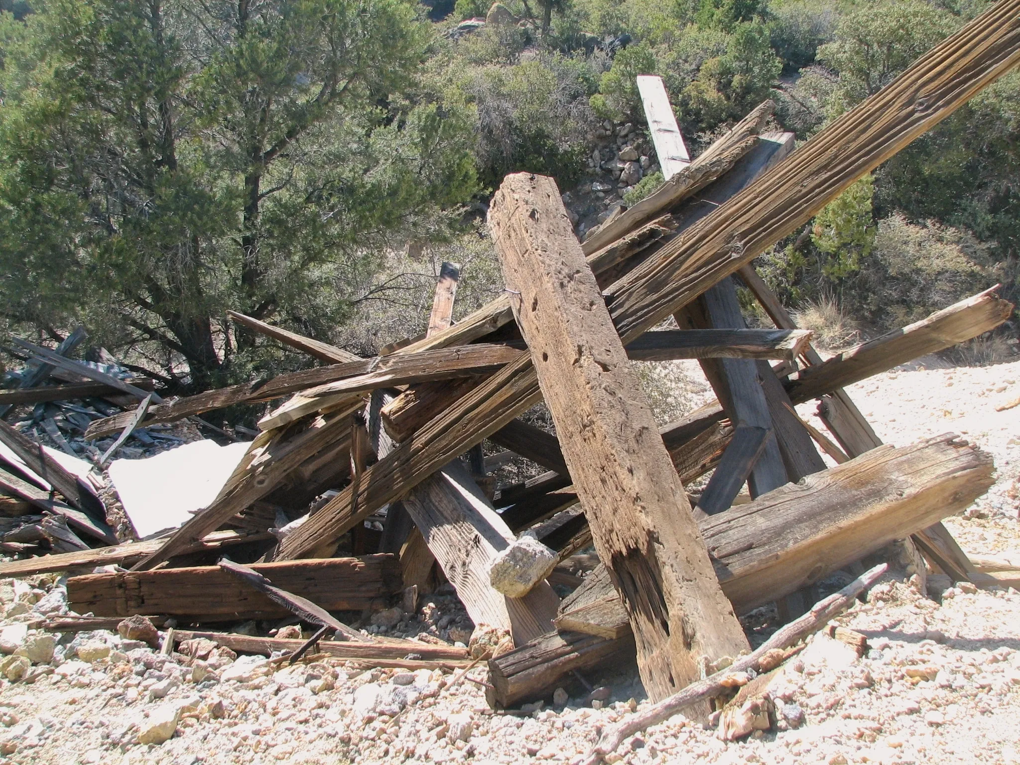 Collapsed wooden mine timbers and planks on a rocky hillside at Giant Ledge Mine.