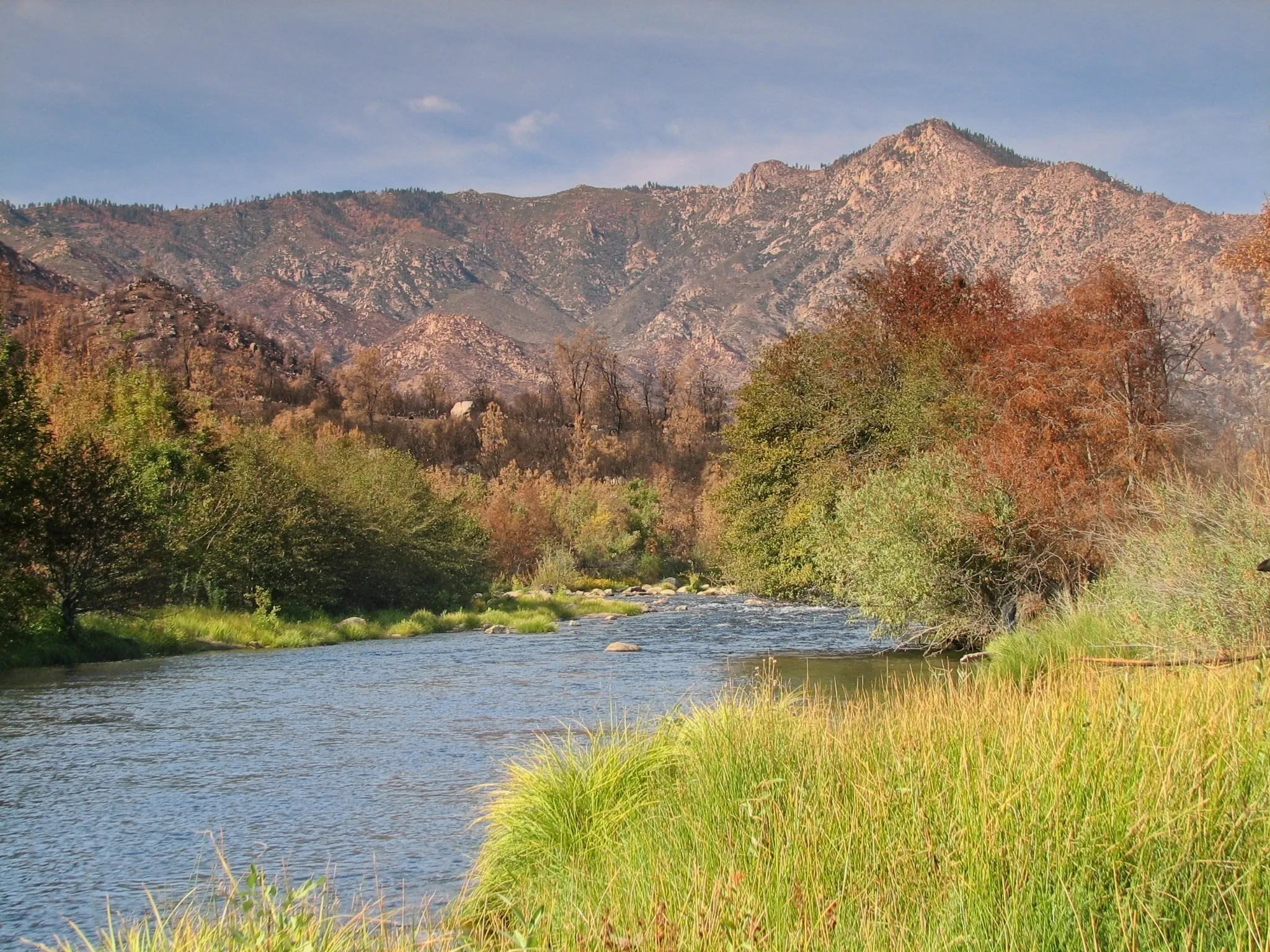 Kern River valley with autumn foliage and rocky mountains beyond.