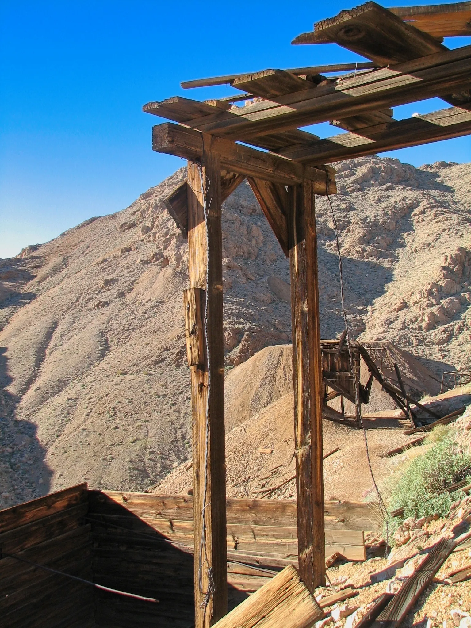 Skeletal wooden mine frame on rocky hillside at War Eagle Mine.