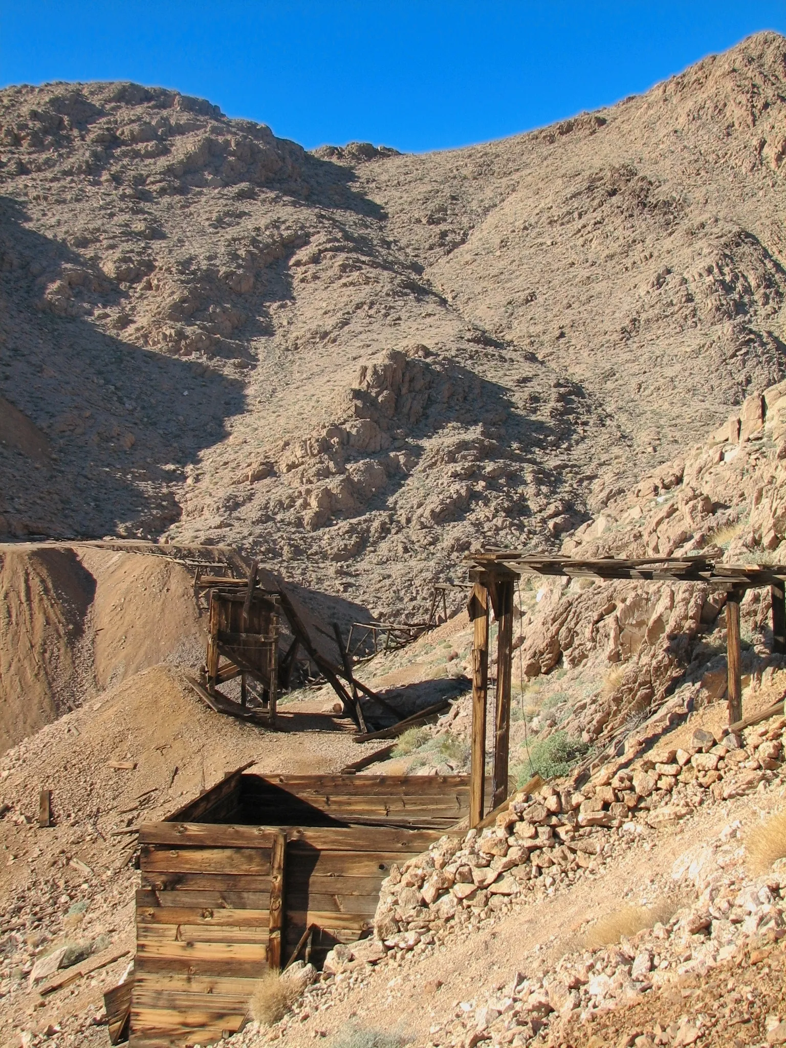 Wooden ore bin and collapsed chute on rocky slope at War Eagle Mine.