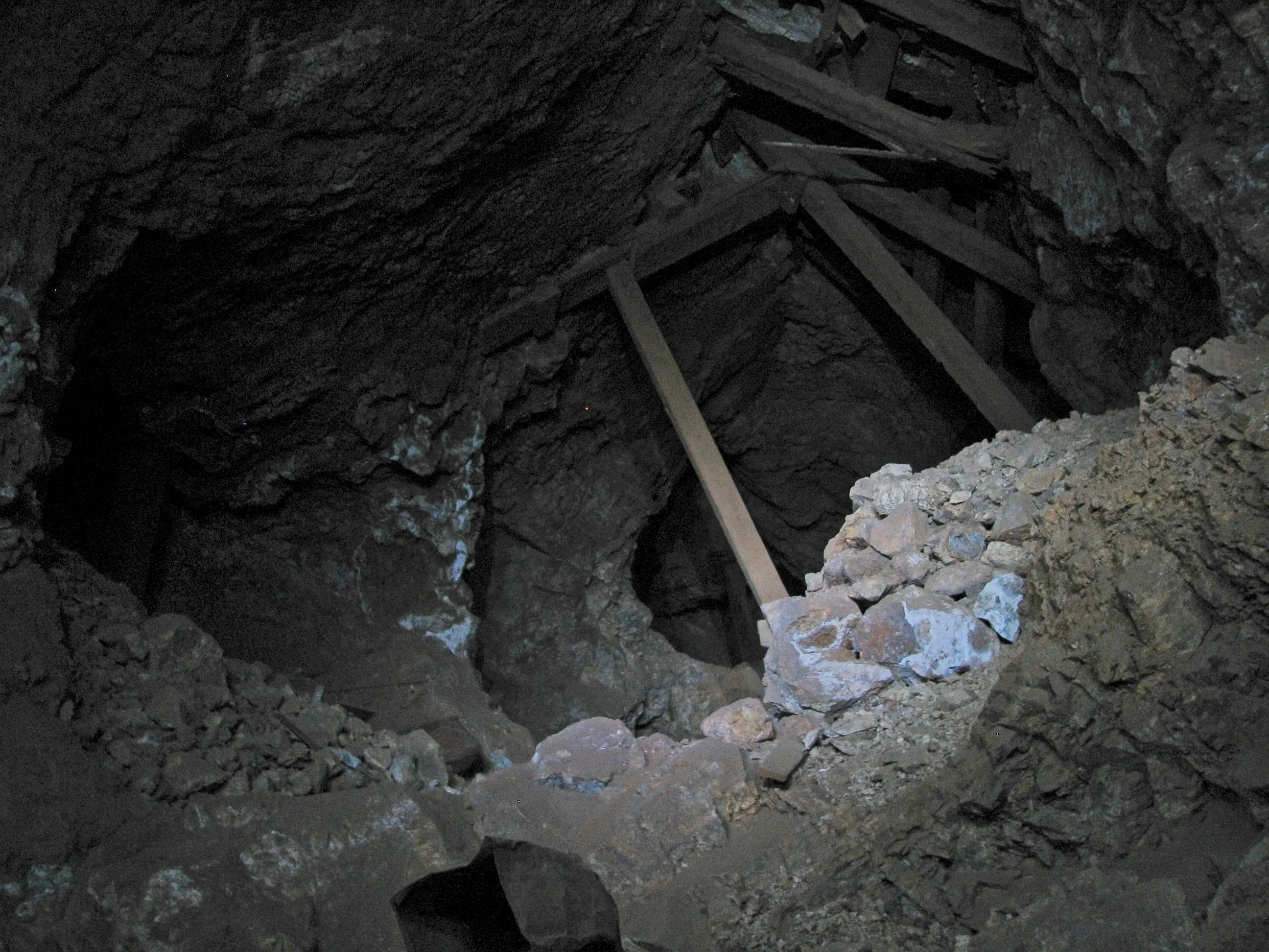 Dark mine shaft entrance with timber shoring at War Eagle Mine.