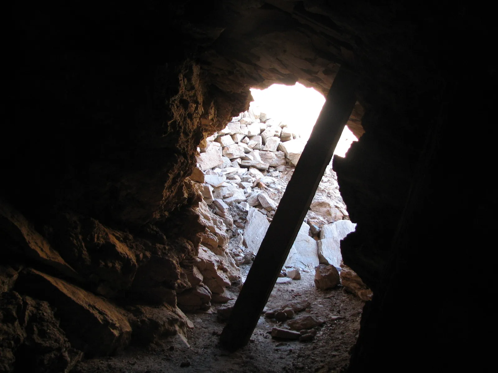 View from inside a mine tunnel toward daylight and a pile of tailings, Big Maria Mountains.