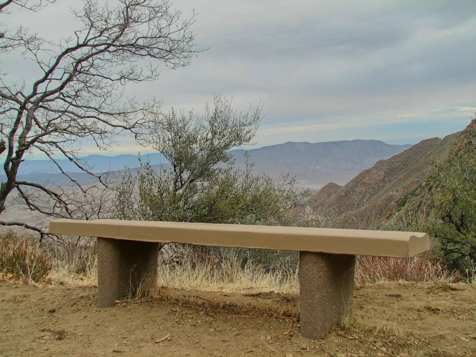 Backless stone bench facing rolling arid hills at a Mount Laguna overlook, California.