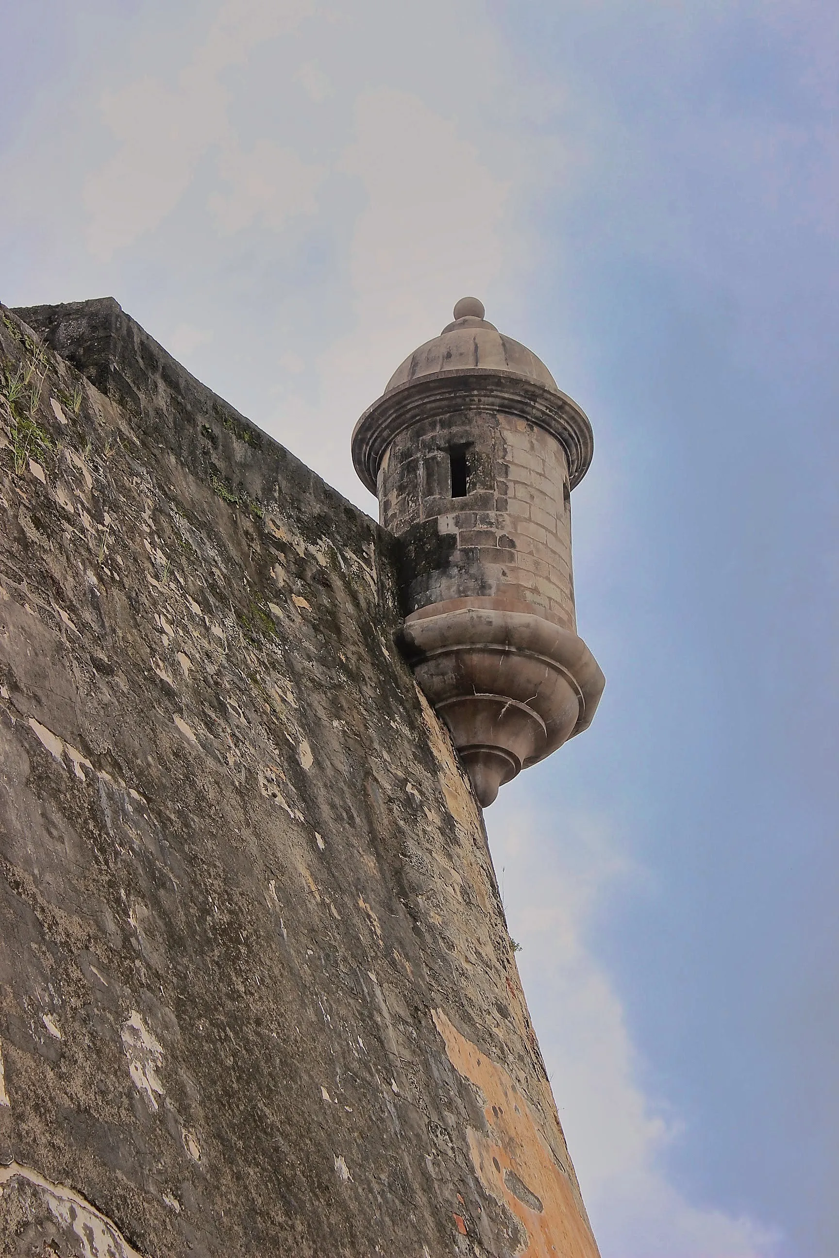 Low-angle view of a domed stone garita on El Morro's weathered corner wall.