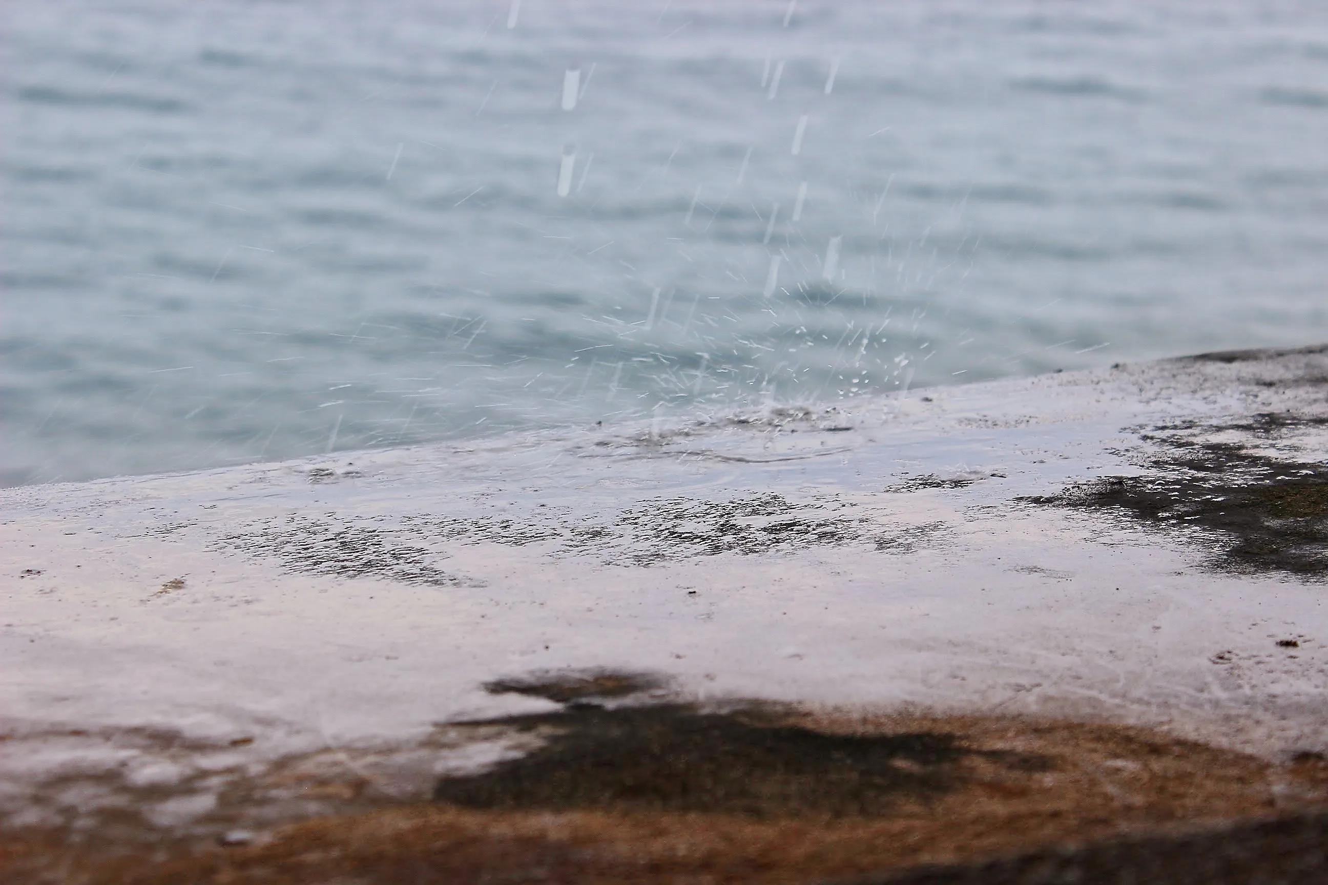 Raindrops splashing on a wet stone ledge at Castillo San Cristóbal.