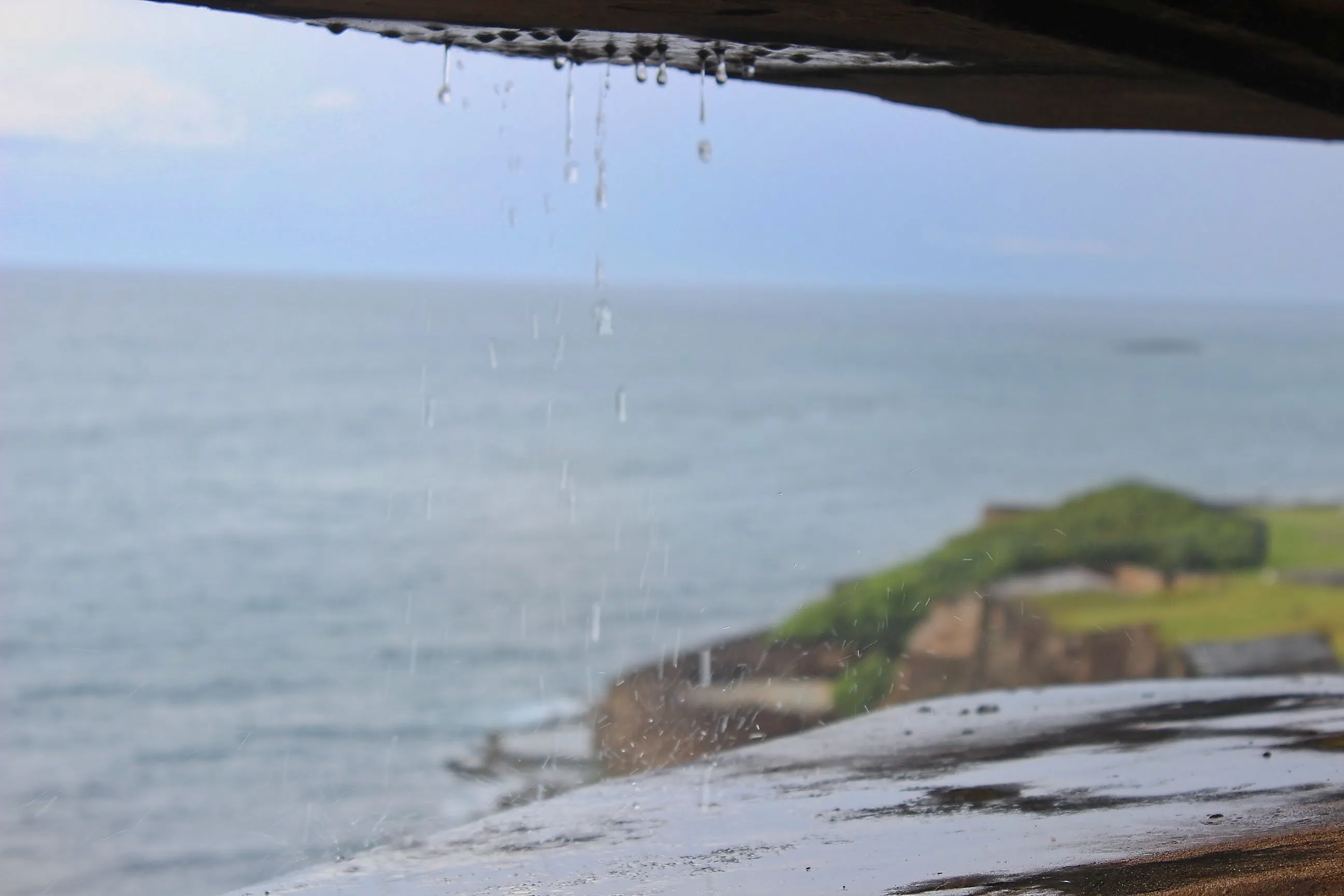 Rain dripping from a fort embrasure overlooking the ocean at Castillo San Cristóbal.