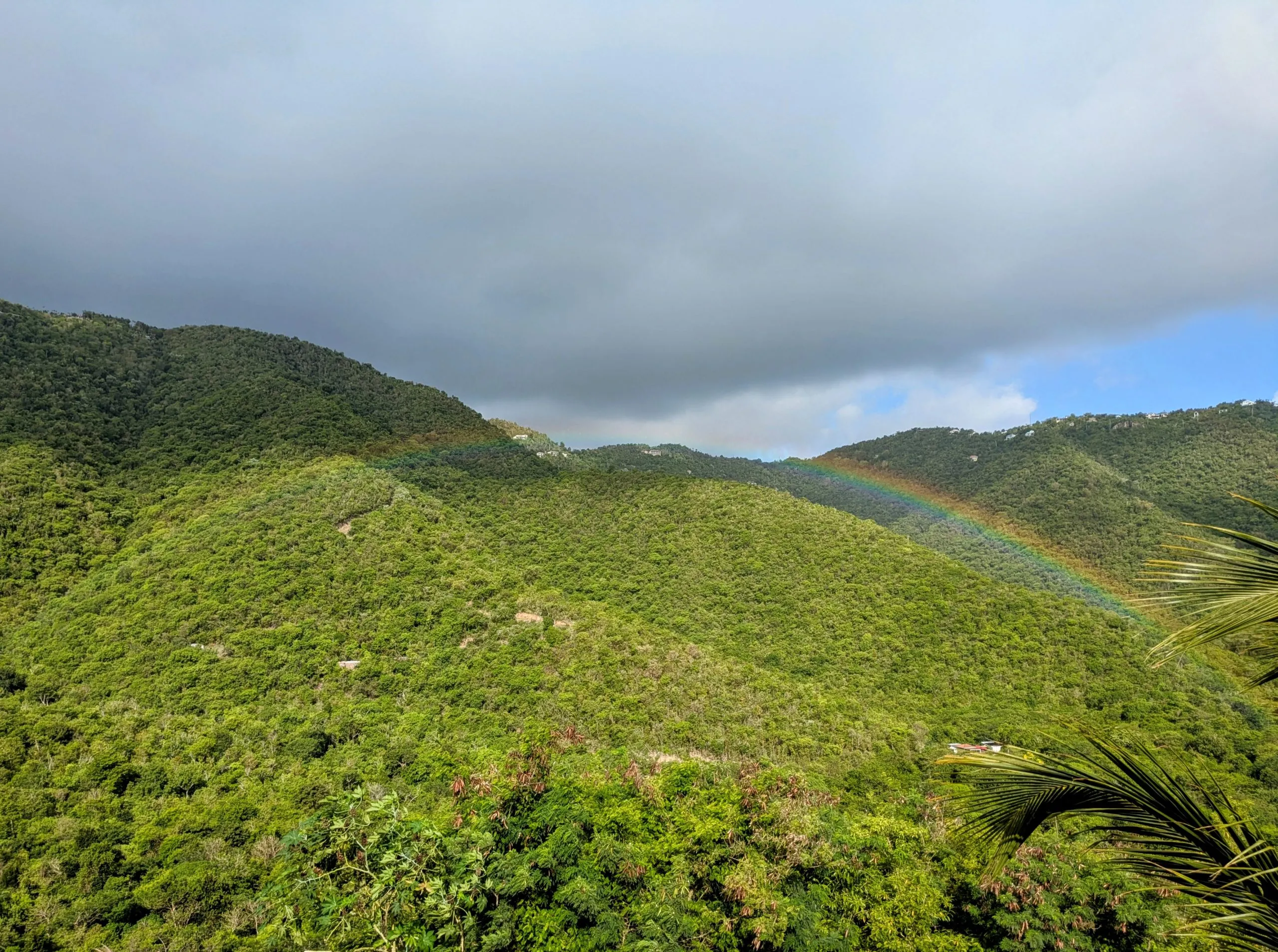 Rainbow over lush green hills above Coral Bay on Saint John, USVI.